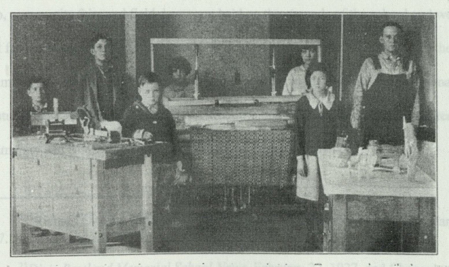 Students in the special class gathered around a weaving loom in a classroom