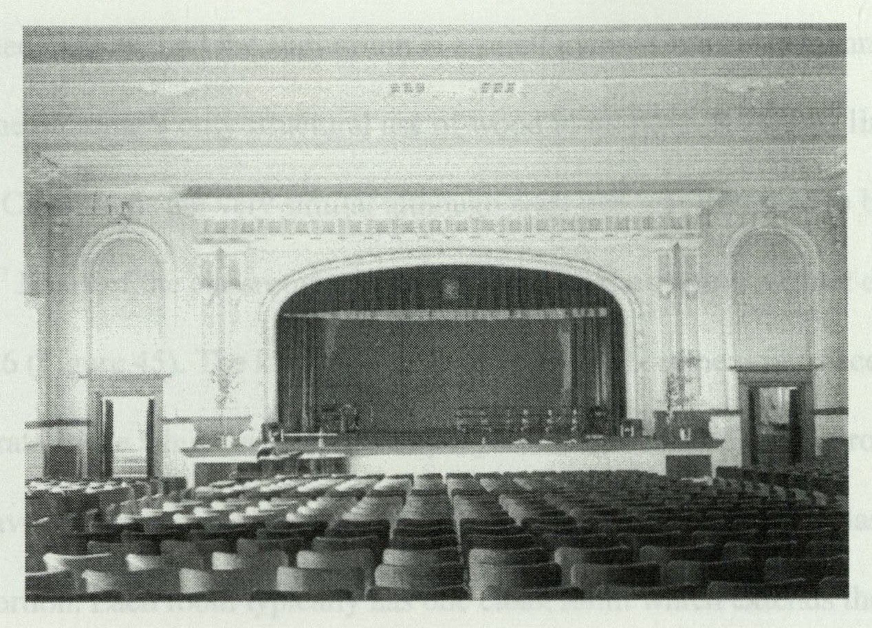 View of the auditorium stage with ornamental stucco proscenium and theater curtain