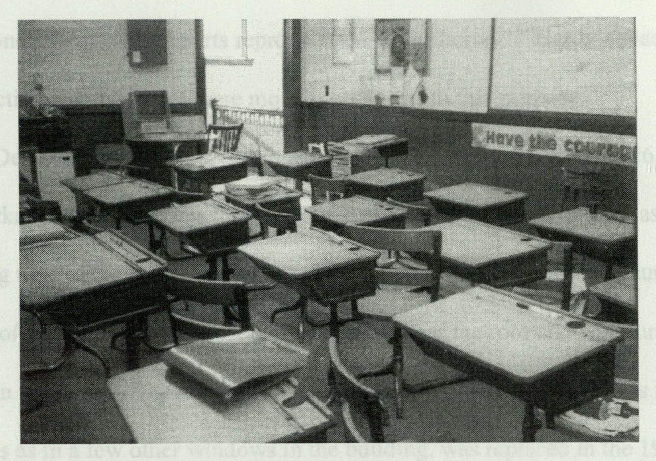 Rows of original 1926 walnut student desks arrayed in a classroom, still in use