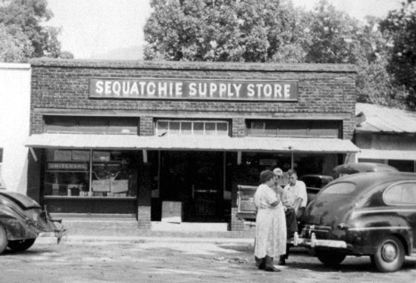 Sequatchie Supply Store circa 1947, brick-front building with hanging sign and a 1940s automobile out front