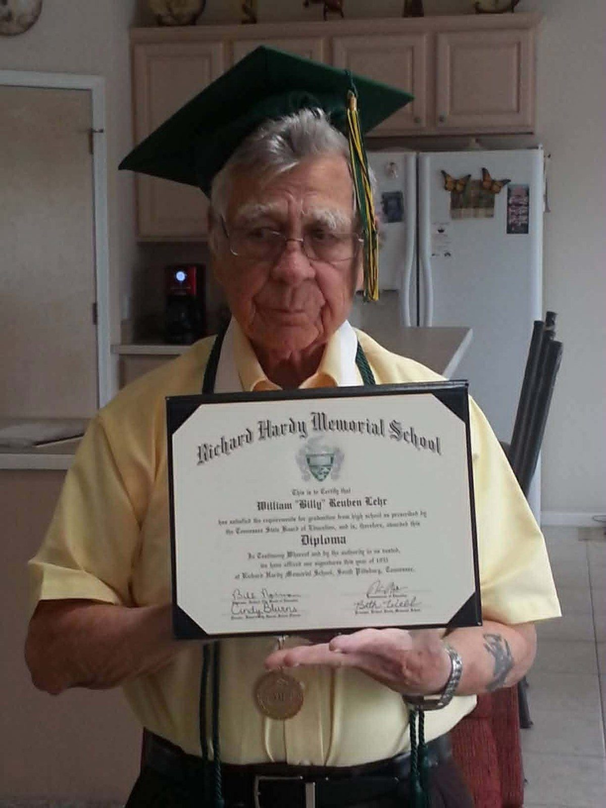 William Reuben Lehr in graduation cap, holding his Richard Hardy Memorial honorary diploma in 2013